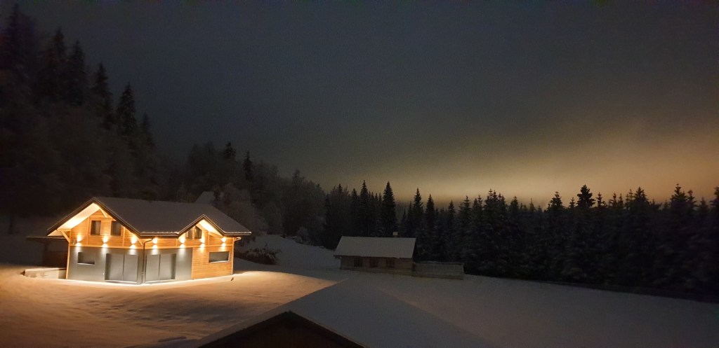 chalet dans le froid syberien des forets du jura illuminé