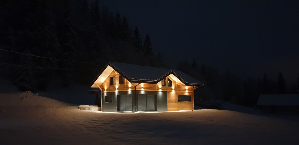 chalet en hiver illuminé dans la nuit froide du jura