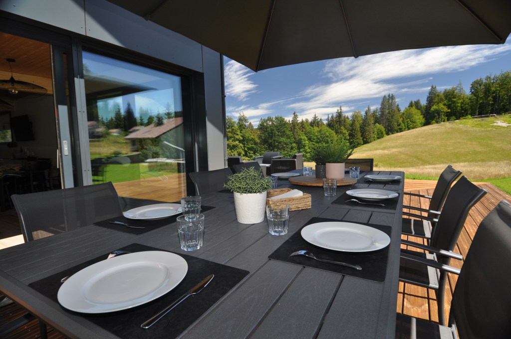 table a manger en exterieur avec vue foret du jura chalet les rousses