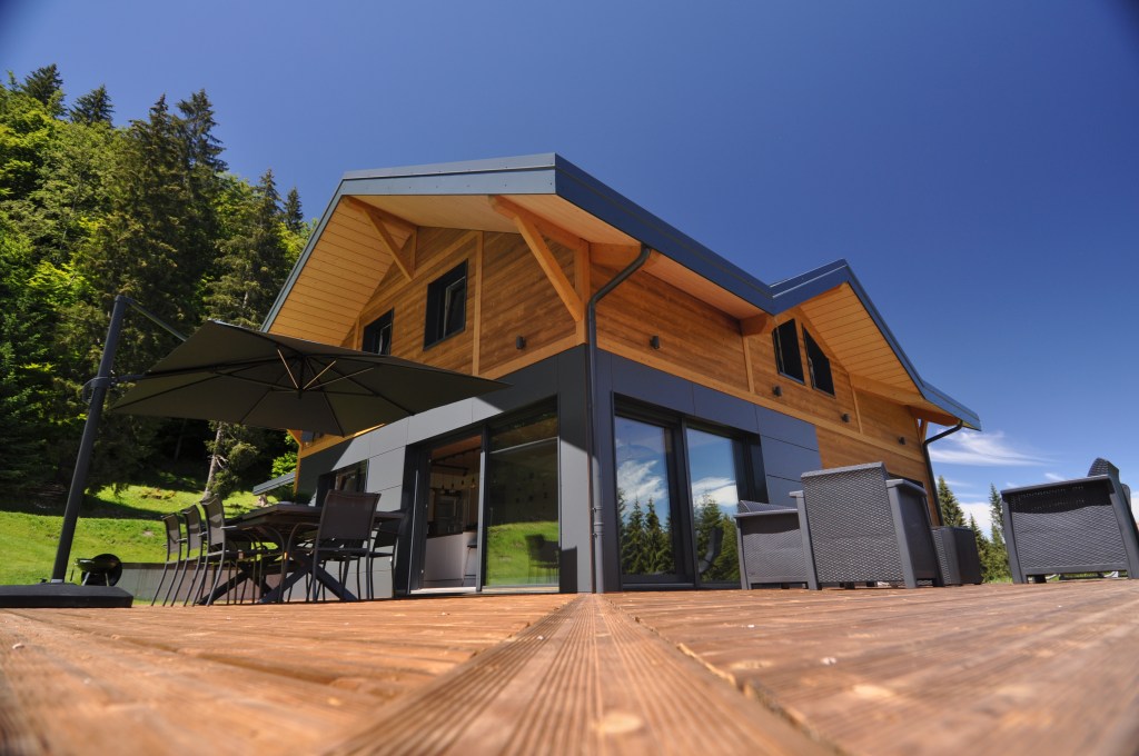 magnifique terrasse avec parasol en été et salon de jardin dans un chalet a louer pou r10 personnes aux rousses